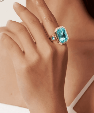 Ring goldfarben mit hellblauen Glasstein an der Hand 7