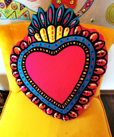 Pink Herz Sofa Kissen dekorert auf gelbem Stuhl.