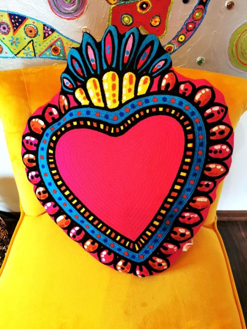 Pink Herz Sofa Kissen dekorert auf gelbem Stuhl.