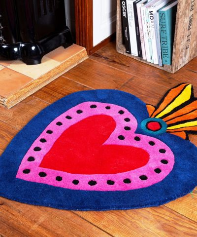 Teppich in Herz Form pink, rot und blau dekoriert.